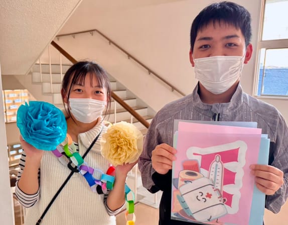 作品を持つ学生の笑顔